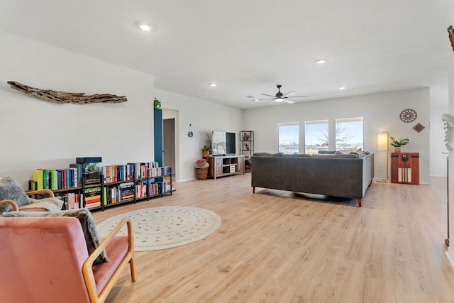 living room featuring light wood-type flooring and ceiling fan