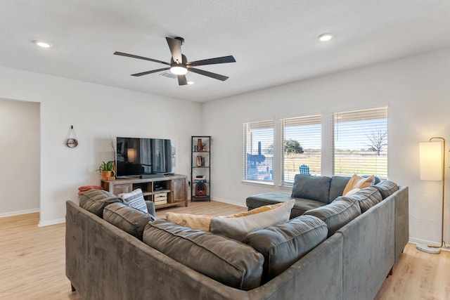 living room with ceiling fan and light hardwood / wood-style flooring