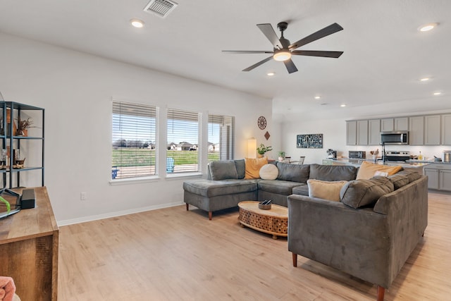 living room featuring ceiling fan and light hardwood / wood-style floors