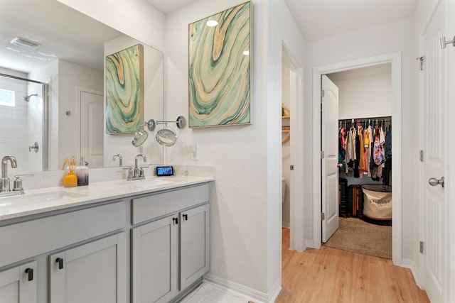 bathroom with a shower with shower door, vanity, and hardwood / wood-style flooring