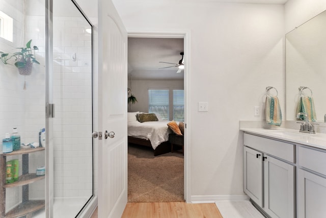 bathroom featuring vanity, ceiling fan, hardwood / wood-style flooring, and walk in shower