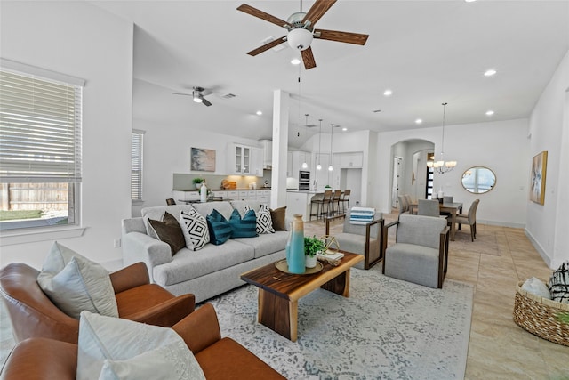 living room with ceiling fan with notable chandelier and light tile patterned flooring