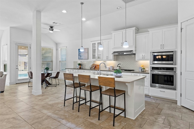 kitchen with ceiling fan, white cabinetry, a kitchen island with sink, stainless steel appliances, and lofted ceiling