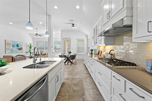 kitchen featuring appliances with stainless steel finishes, white cabinetry, sink, decorative light fixtures, and backsplash