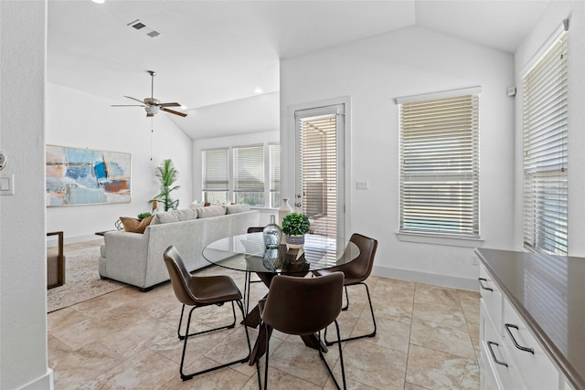 tiled dining area with ceiling fan and vaulted ceiling