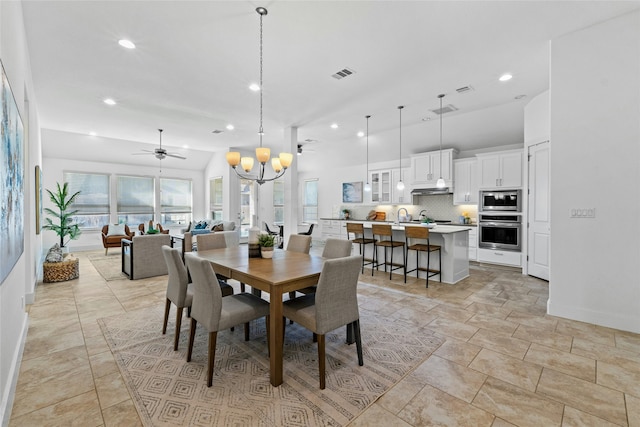 dining space with vaulted ceiling and ceiling fan with notable chandelier