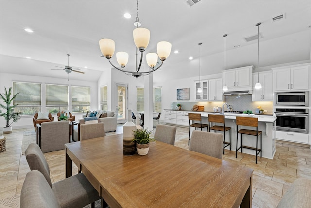 dining room with ceiling fan with notable chandelier and lofted ceiling