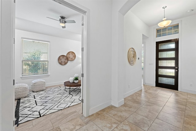 entrance foyer with light tile patterned floors and ceiling fan