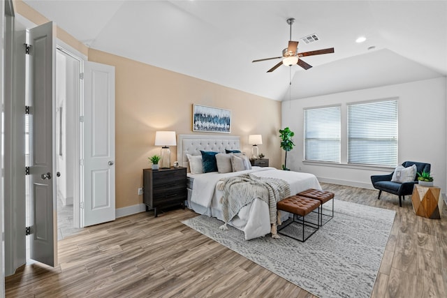 bedroom with lofted ceiling, light hardwood / wood-style flooring, and ceiling fan