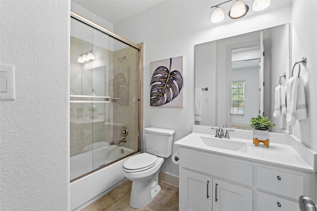 full bathroom with vanity, toilet, bath / shower combo with glass door, and tile patterned floors