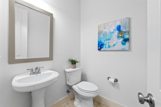 bathroom featuring sink, toilet, and tile patterned flooring