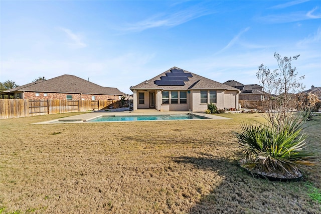 back of property with a fenced in pool, a yard, solar panels, and a patio