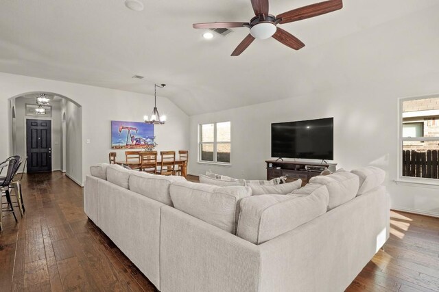 living room featuring lofted ceiling, dark wood-type flooring, and ceiling fan with notable chandelier