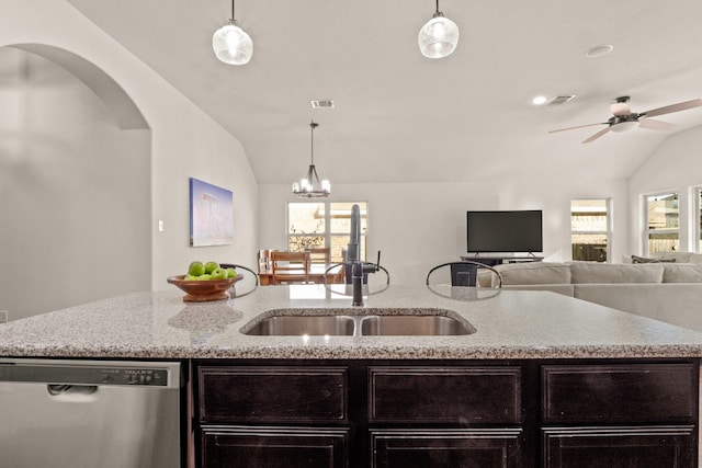 kitchen featuring vaulted ceiling, stainless steel dishwasher, sink, and pendant lighting