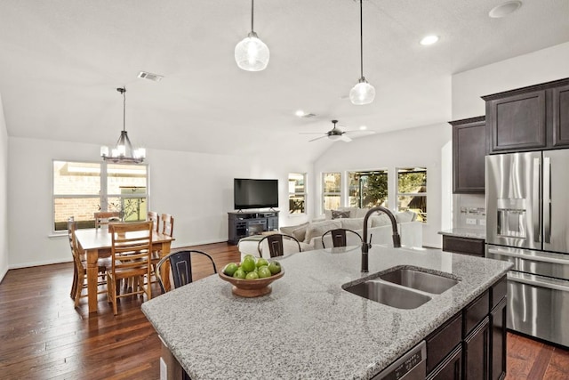 kitchen featuring stainless steel fridge with ice dispenser, a sink, a center island with sink, dark brown cabinetry, and lofted ceiling