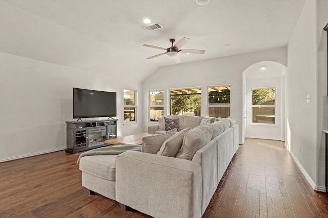 living room featuring ceiling fan, arched walkways, dark wood finished floors, lofted ceiling, and baseboards