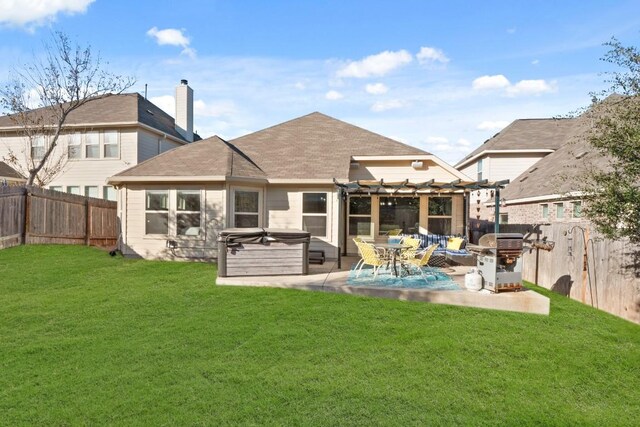 back of property featuring a yard, a hot tub, and a patio area