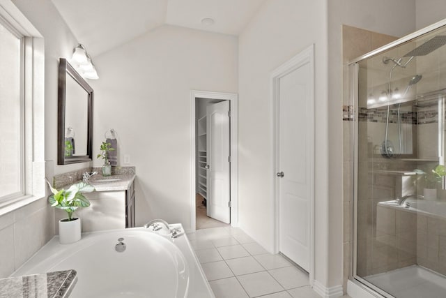 bathroom featuring independent shower and bath, vanity, vaulted ceiling, and tile patterned floors