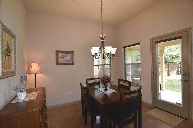 dining area featuring dark tile patterned flooring and a chandelier