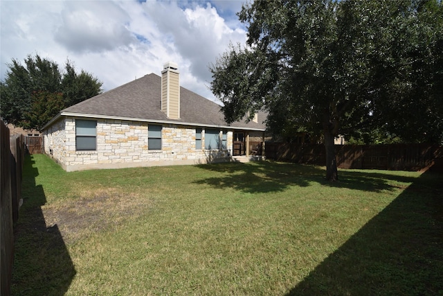 rear view of house featuring a lawn