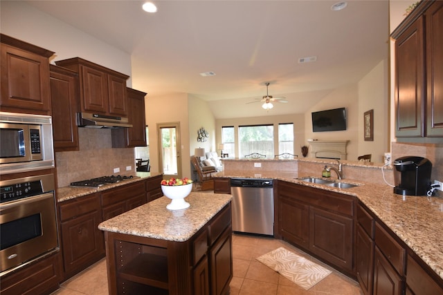 kitchen with lofted ceiling, tasteful backsplash, kitchen peninsula, sink, and appliances with stainless steel finishes