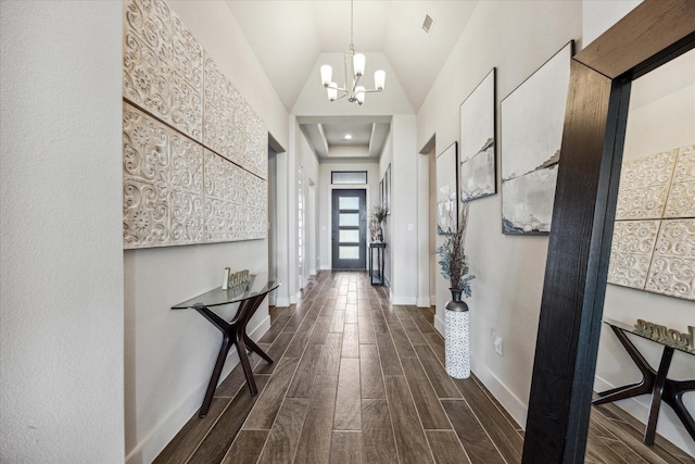 corridor with high vaulted ceiling and a notable chandelier