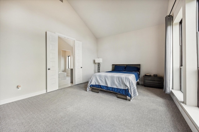 bedroom featuring lofted ceiling, ensuite bath, and carpet floors