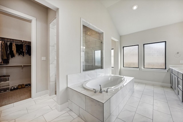 bathroom featuring lofted ceiling, vanity, and shower with separate bathtub