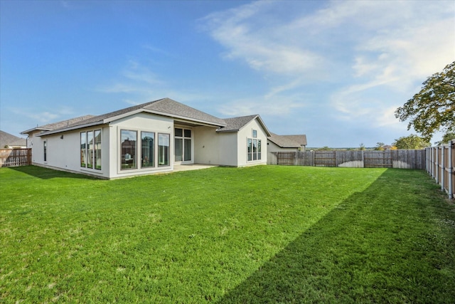 rear view of house featuring a yard