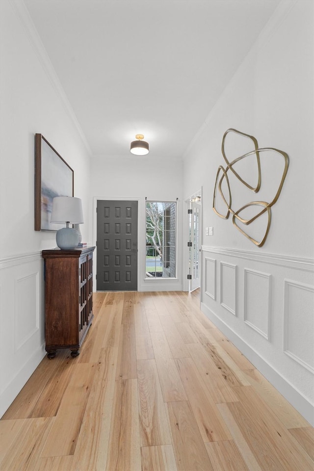 entryway featuring light hardwood / wood-style floors and crown molding