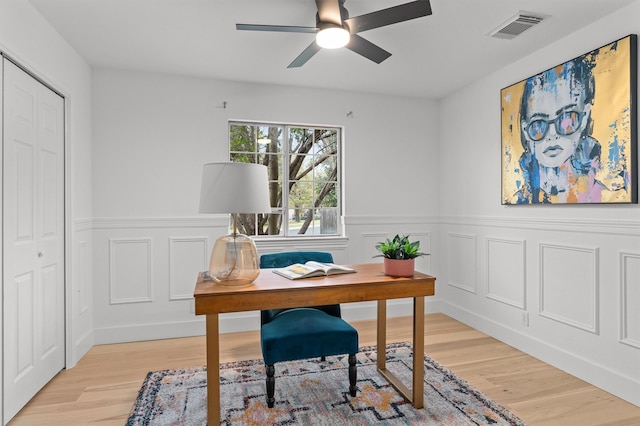 office with ceiling fan and light hardwood / wood-style flooring