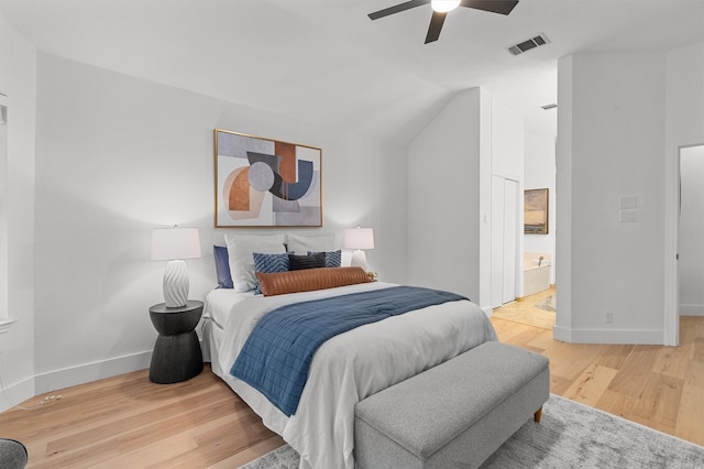 bedroom with ensuite bathroom, ceiling fan, vaulted ceiling, and hardwood / wood-style flooring