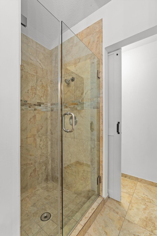 bathroom featuring a textured ceiling and walk in shower