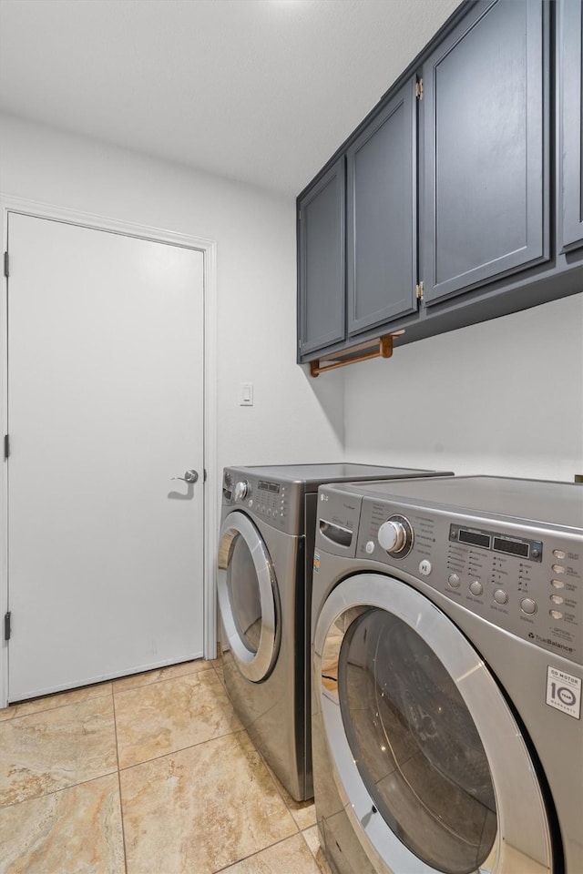 laundry room featuring cabinets, light tile patterned floors, and independent washer and dryer