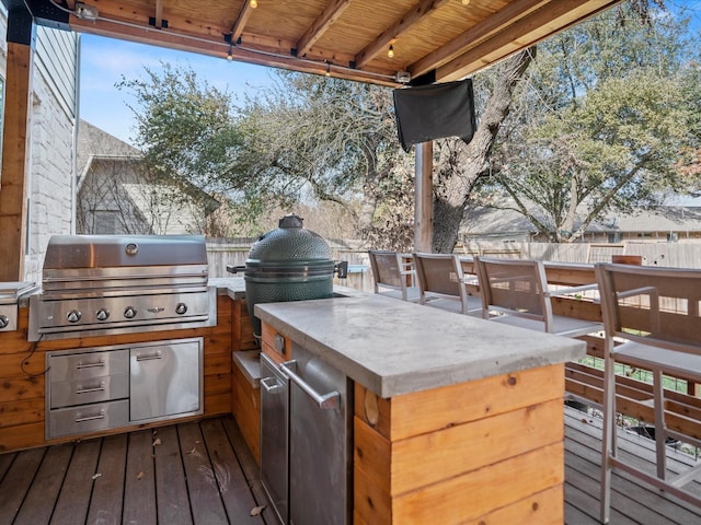 view of patio / terrace featuring a wooden deck, area for grilling, exterior kitchen, and exterior bar