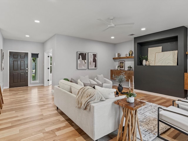 living room with ceiling fan and light wood-type flooring