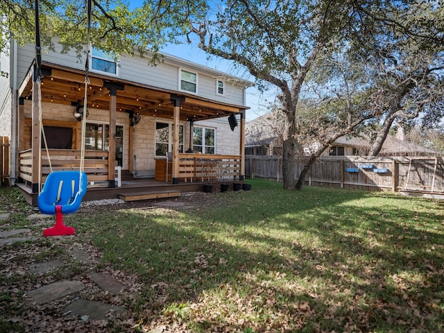 rear view of house featuring a lawn and a wooden deck