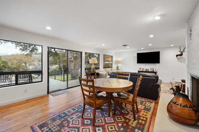 dining room with a fireplace and light hardwood / wood-style flooring