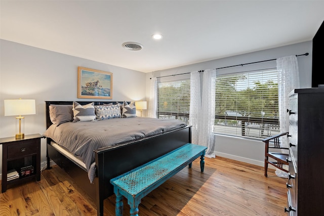 bedroom featuring hardwood / wood-style flooring and multiple windows