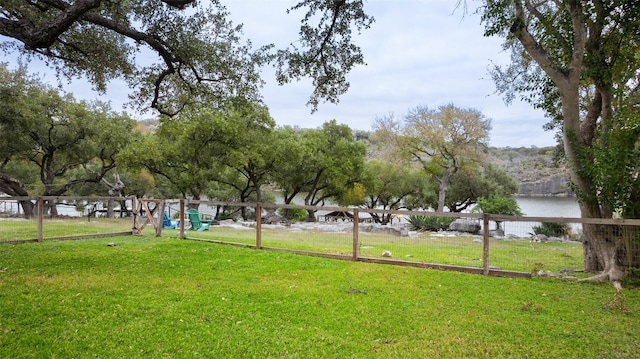 view of property's community with a water view and a lawn