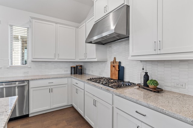 kitchen featuring white cabinets, dark wood-type flooring, stainless steel appliances, decorative backsplash, and light stone counters