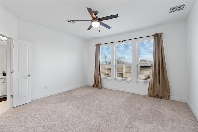 empty room featuring ceiling fan and light carpet