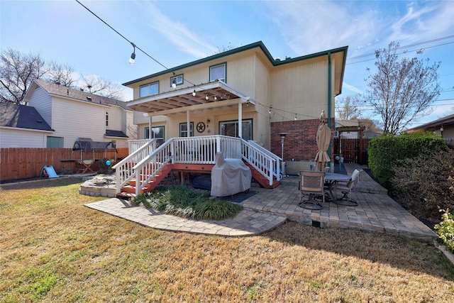 back of house featuring a lawn and a patio