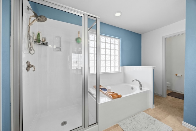 bathroom with tile patterned floors, toilet, and shower with separate bathtub