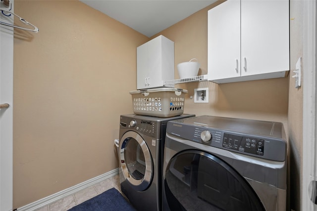 washroom featuring cabinets, separate washer and dryer, and light tile patterned flooring