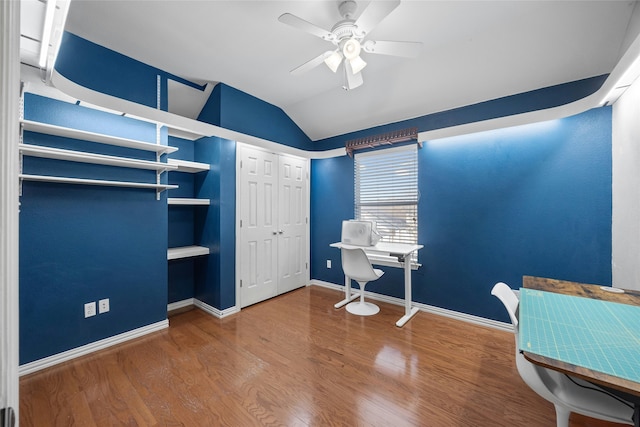 office space featuring ceiling fan, vaulted ceiling, built in features, and wood-type flooring