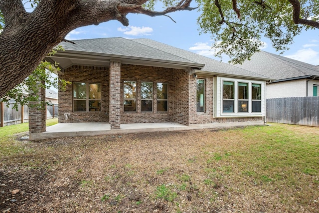 back of house featuring a lawn and a patio