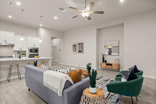 living room featuring ceiling fan and light hardwood / wood-style flooring