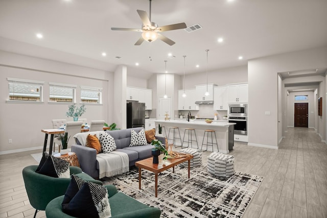 living room with ceiling fan and light wood-type flooring