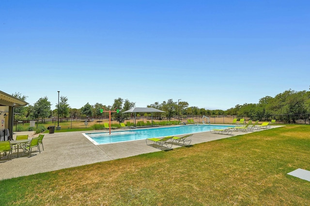 view of swimming pool featuring a patio area and a yard